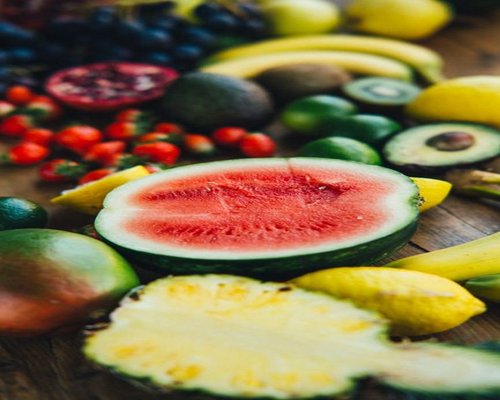 Fresh Mexican produce including papaya and avocados on a wooden table