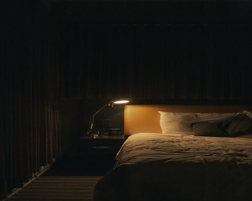 Reading a digital tablet in a dark room with a small bedside lamp